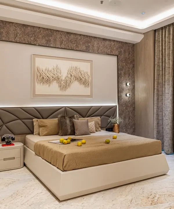This master bedroom features a sophisticated palette of beige and brown, with a custom geometric headboard and integrated ambient lighting. The textured wallpaper behind the bed adds depth and a touch of opulence.