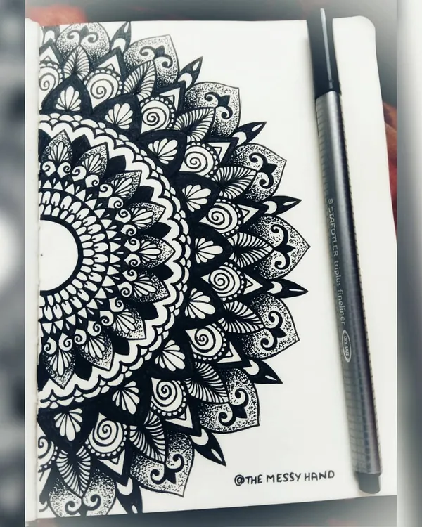 A semi-circle mandala drawn in my sketchbook. Making mandalas is a form of meditation for me, helping me concentrate and find peace.