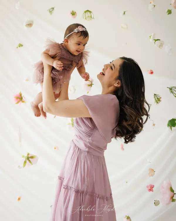 A mother’s joy is pure magic. I designed this session with a soft, ethereal feel, using falling flowers to create a dreamlike atmosphere that perfectly frames this beautiful, candid moment of love.