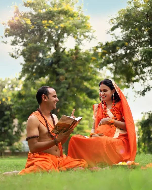A husband reads from a holy book to his wife in this Ram-Sita themed outdoor shoot. It’s a beautiful way to represent faith and togetherness during your pregnancy journey.