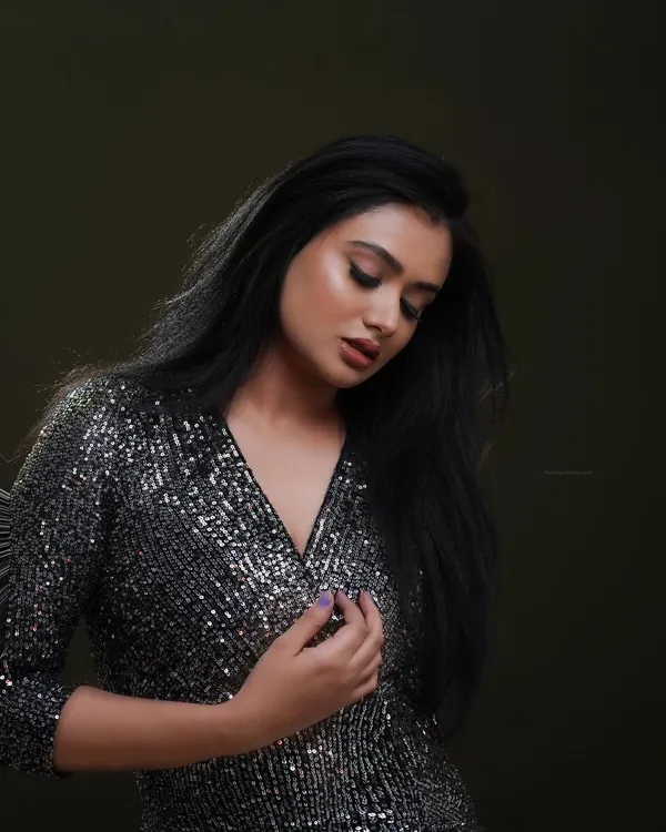 A moody and glamorous shot for a model's portfolio. The single-source lighting highlights the texture of the sequined dress while casting soft shadows, creating a sophisticated look.
