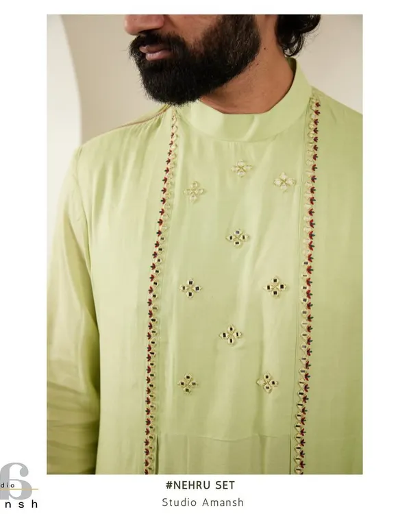 A close-up of the light green kurta, showing the delicate embroidery and mirror work along the placket, worn under our emerald Nehru jacket.