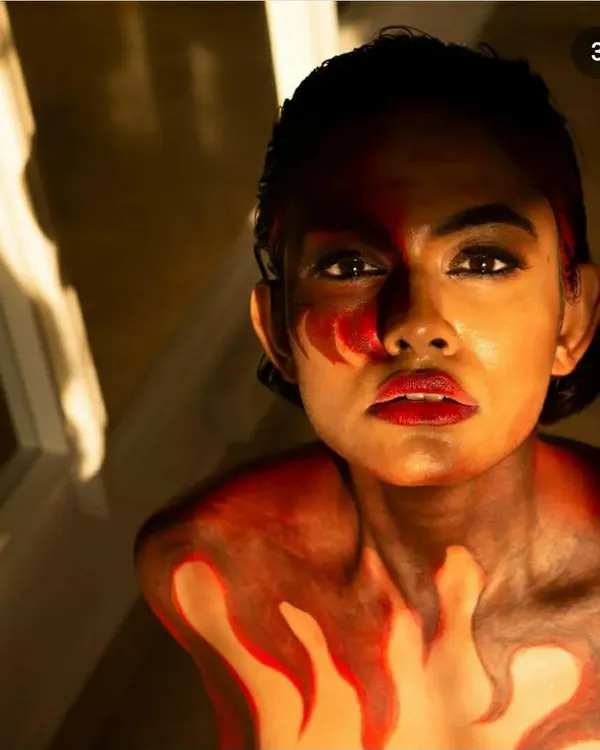 The final look of a fire-themed body painting project. I used a blend of red, orange, and dark tones to create the illusion of flames rising up the model's chest and neck.