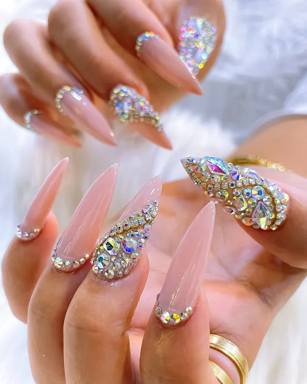 An absolutely stunning example of high-glamour nail art. This set features long, nude stiletto nails with a heavy encrusting of Swarovski crystals in various shapes and sizes.