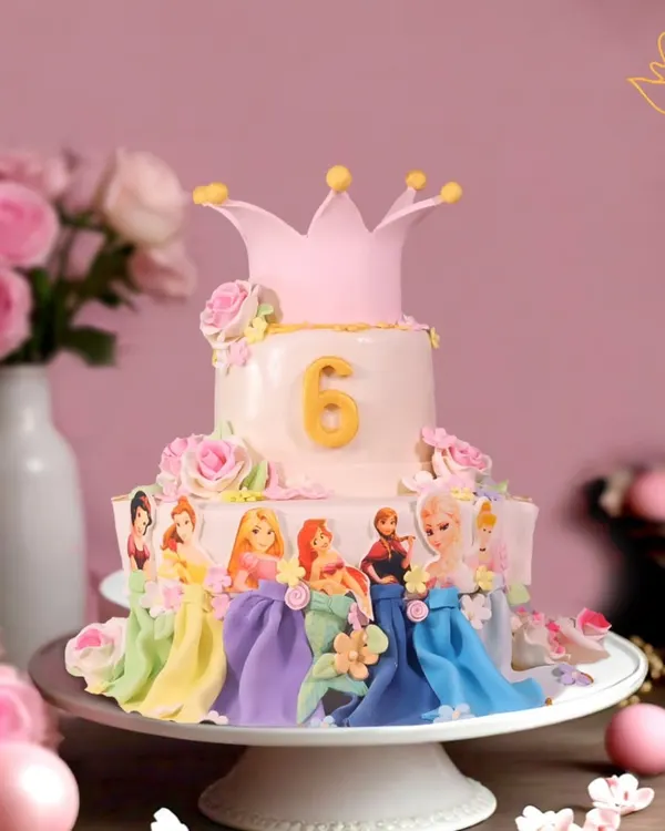 This two-tier Disney Princess cake is a fairytale dream come true, featuring beloved princesses like Elsa and Rapunzel, all handcrafted with fondant and topped with a royal crown for a magical 6th birthday.
