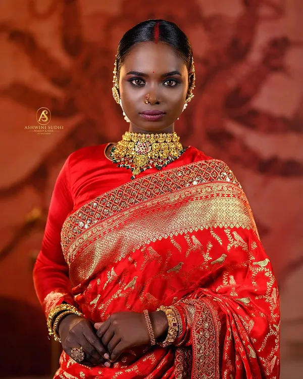 This portrait captures the strength and grace of a South Indian bridal look. I used dramatic lighting to accentuate the rich red of the saree and the intricate gold jewelry, creating a powerful image that’s perfect for a professional portfolio.
