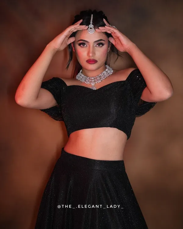 A bold and dramatic pose showcasing a stunning diamond-look necklace and maang tikka. This set is perfect for making a statement at a reception or cocktail party.