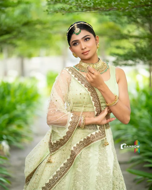 An elegant portrait in a light green lehenga. The soft, natural light and the model's graceful pose create a serene and beautiful image.