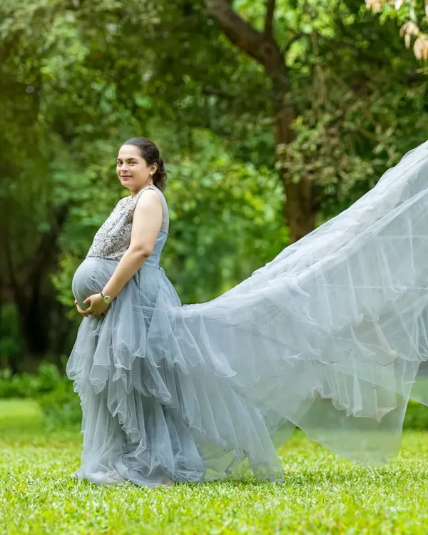 The long, ethereal trail of this grey gown catches the wind perfectly, creating a sense of movement and grace. The embellished bodice adds a touch of sparkle to the look.