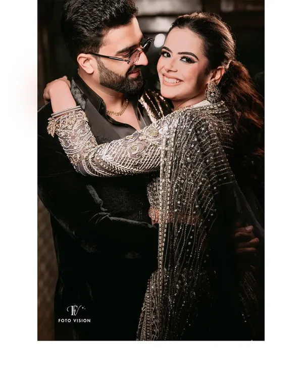 A warm and happy embrace between the couple, their smiles lighting up the frame, showcasing their effortless chemistry.
