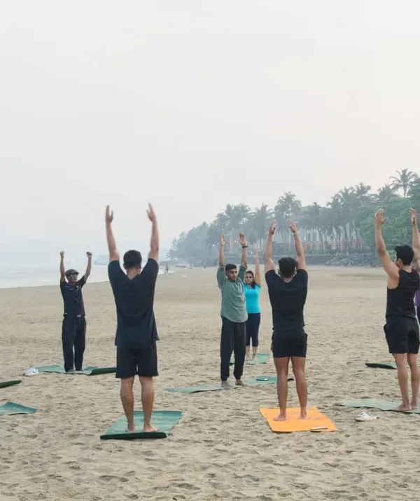 A sunrise yoga session begins with greeting the sun. Here, my group class is performing Urdhva Hastasana, a simple upward salute that stretches the spine and opens the body, setting the tone for the practice ahead.