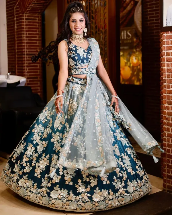 A client looking absolutely radiant in a deep teal and silver floral embroidered lehenga. This is a stunning choice for an engagement or sangeet.