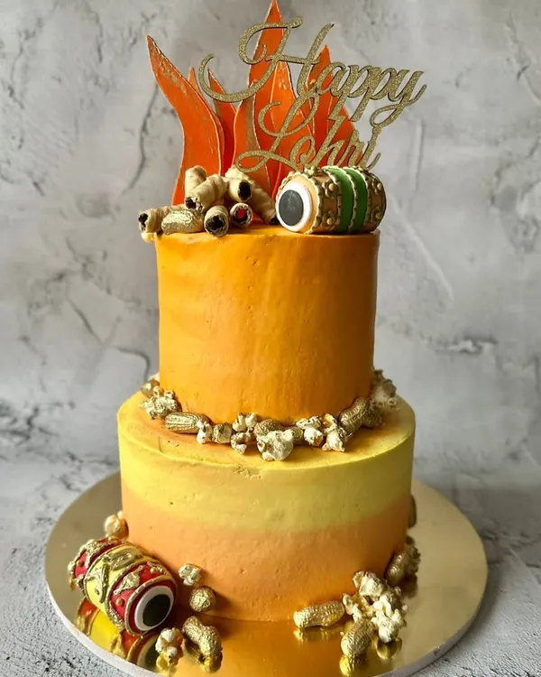I designed this two-tiered cake to celebrate the vibrant festival of Lohri. It features a bonfire-inspired color gradient and is decorated with edible peanuts, a dhol, and a "Happy Lohri" topper.