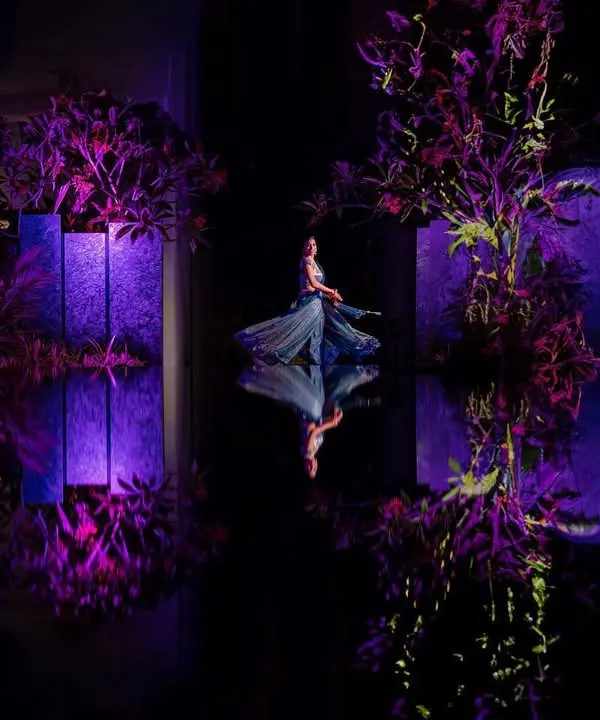 A fairytale moment captured during a sangeet performance. We used the reflective floor and dramatic purple lighting to create this dreamlike, symmetrical shot, turning a dance into a piece of art. This is how we find magic in every event.