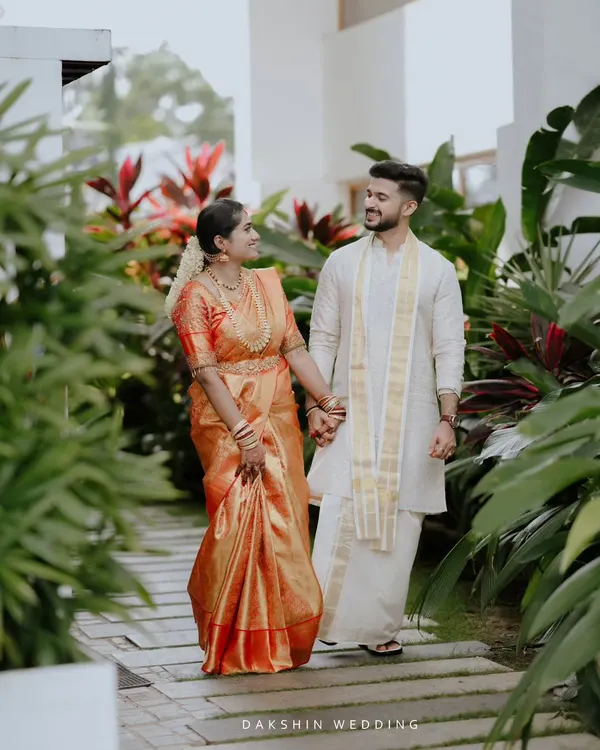 A South Indian couple takes a serene walk together, dressed in a beautiful Kanjeevaram saree and traditional mundu. I capture these quiet moments of connection amidst the wedding day buzz.