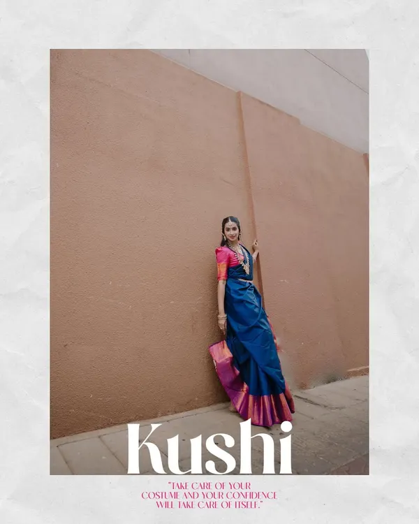 A full-length editorial portrait for a model's book. The strong pose, vibrant saree, and minimalist background create a high-fashion look.