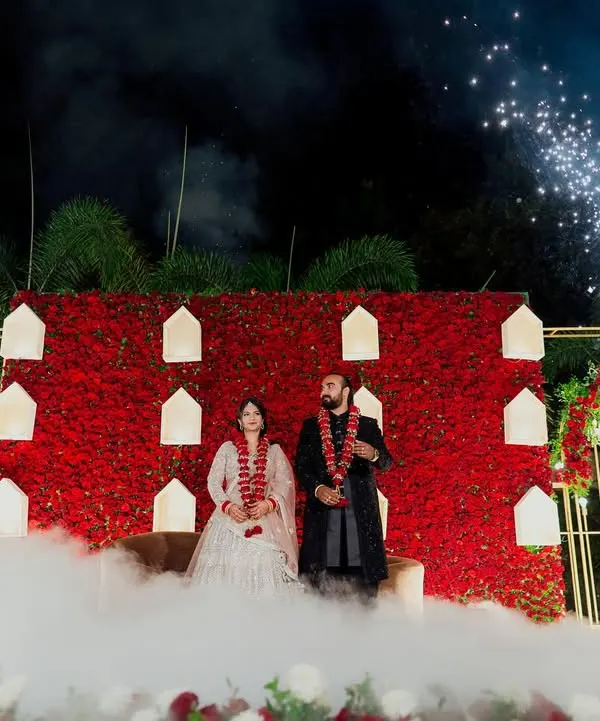 A truly spectacular reception stage with a wall of red roses, dramatic smoke, and fireworks. We use our expertise in lighting and composition to capture the grandeur of your celebration.