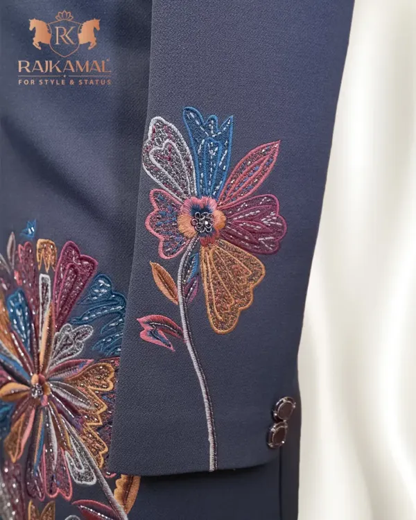 This is a detail of the sleeve on a modern Indo-Western jacket. The vibrant, multi-colored floral threadwork stands out against the dark fabric, offering a contemporary twist on traditional embroidery for a stylish fusion look.