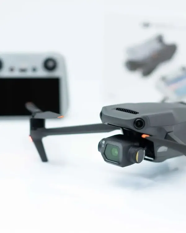 A product shot of our DJI Mavic 3 Classic drone next to its controller. This is the professional equipment we use to capture high-quality aerial cinematography.