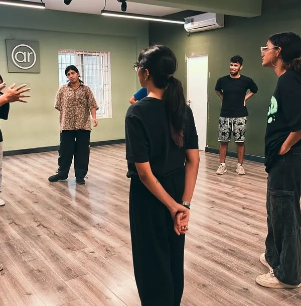 A typical moment in one of our classes. An instructor breaks down a move for a small group of students, ensuring everyone understands and feels comfortable. This is a safe space to learn and grow.
