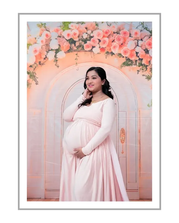 A radiant solo portrait in front of our dreamy floral arch. The mom-to-be looks beautiful in a light pink gown that perfectly matches the soft tones of the flowers. This is a classic and elegant maternity shot.
