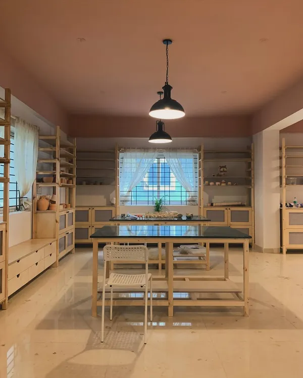 The main workspace of our studio, with custom built tables and shelves waiting to be filled with your creations. We designed it with natural wood and warm tones to feel open and welcoming, with plenty of natural light for you to work by during the day.