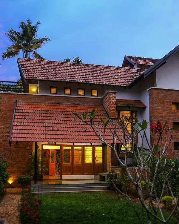 We designed this landscape to complement the home's traditional brick and tile architecture. The strategic placement of flowering shrubs, a manicured lawn, and subtle uplighting creates a warm, inviting entrance that feels both grand and natural.