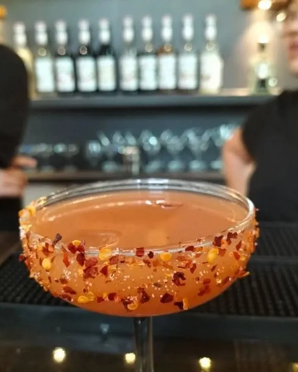 A spicy twist on a classic. This cocktail features a chili flake rim, adding a kick of heat that perfectly complements the drink's flavor profile.