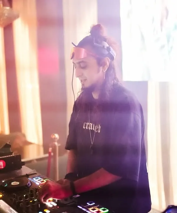 A focused moment at the DJ console, surrounded by a hazy glow. Here, I'm lining up the next track on my Pioneer setup.