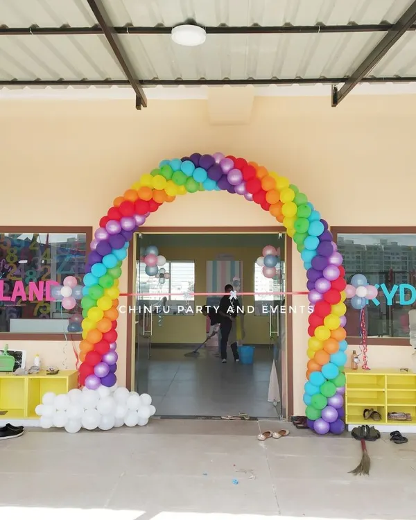A welcoming rainbow balloon arch for a playschool entrance. This colorful decoration is perfect for school openings, annual days, or children's events.