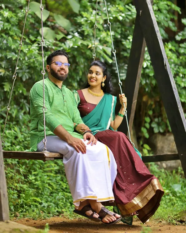 A relaxed and natural shot of a couple on a wooden swing, set in a lush green garden. A perfect example of our candid pre-wedding photography.