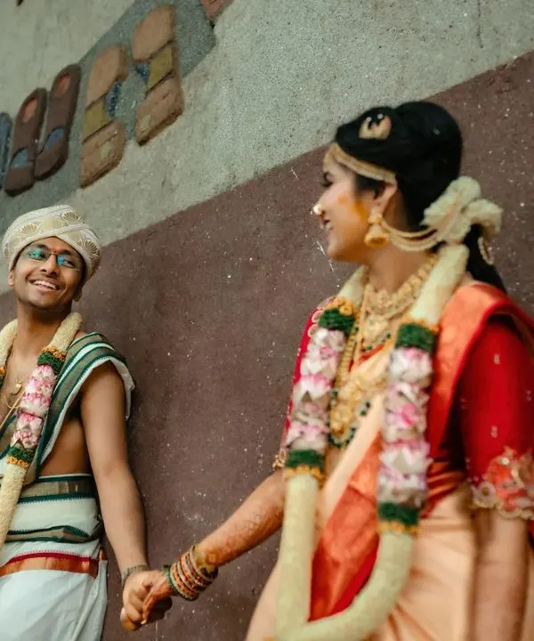 A candid moment of a newly married couple sharing a smile. We love capturing these quiet, happy interactions right after the main wedding rituals are complete.