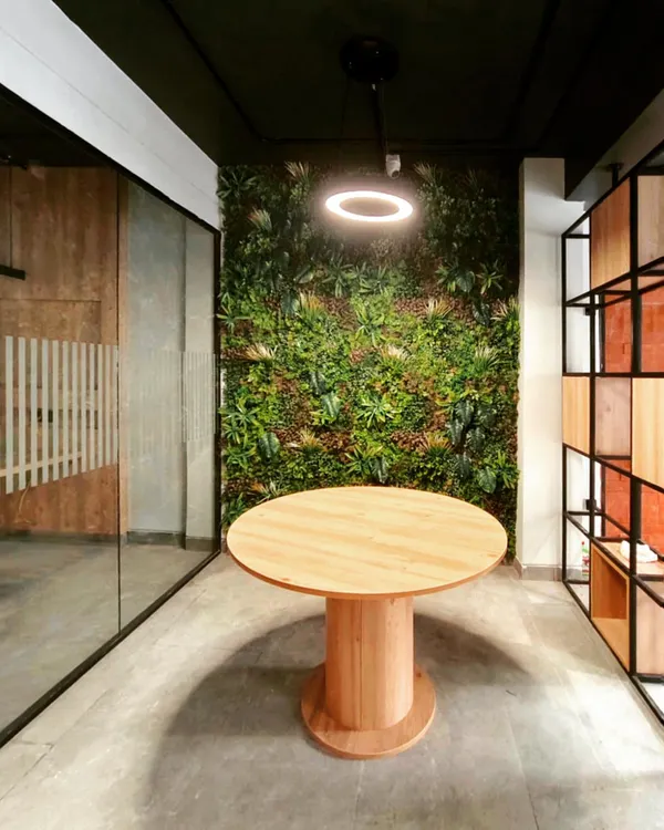 A vibrant green wall serves as the focal point in this modern office, showcasing our biophilic design approach. We integrate natural elements like this to create a refreshing and productive atmosphere that reduces stress and improves well-being for the team.