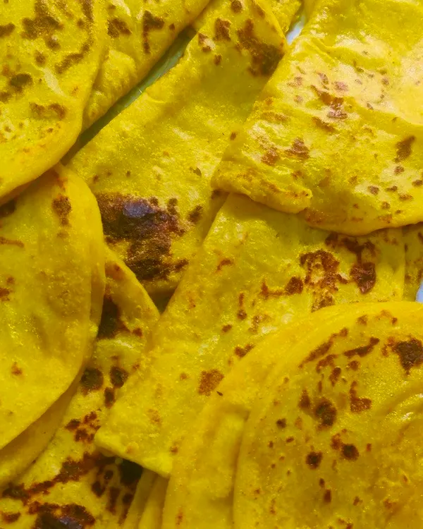 A pile of freshly made Holige, also known as Obbattu. This traditional sweet flatbread, stuffed with a lentil and jaggery filling, is a festive delicacy in Karnataka.