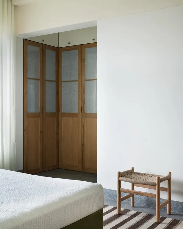 These corner wardrobe doors are crafted from light oak with frosted glass panels. I designed them to provide visual softness and texture in the master bedroom, hiding storage without adding visual weight.