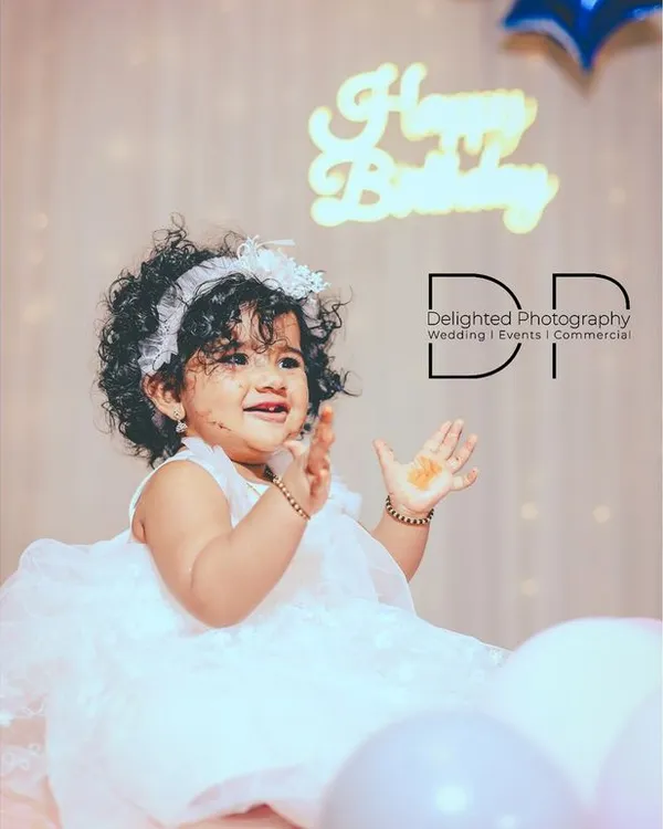 Capturing the pure delight of a first birthday. This little girl's happy claps and bright smile made for a perfect portrait.