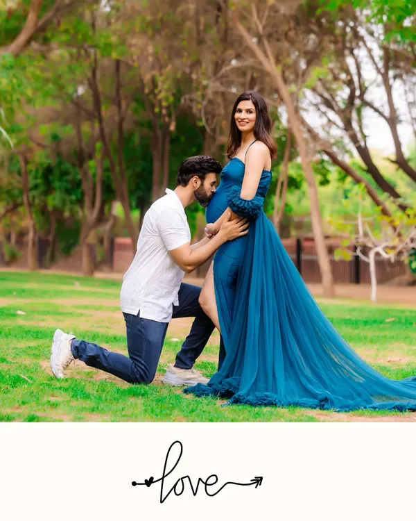 A classic, romantic portrait of an expecting couple in a beautiful park setting, capturing the quiet joy before the baby arrives. This outdoor maternity photo highlights the connection between partners.