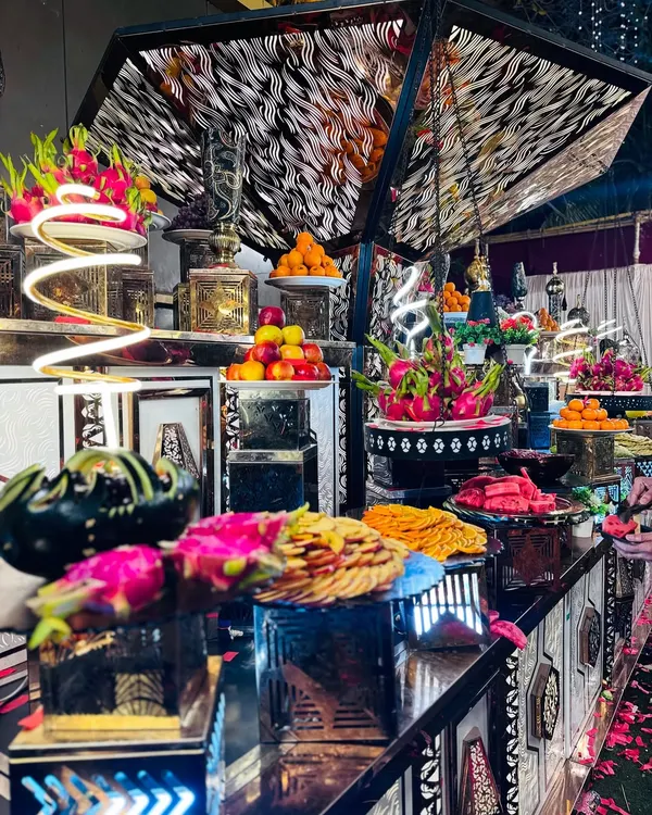 My fruit counters are a work of art. This black and silver setup features an elaborate display of exotic fruits like dragon fruit, apples, and oranges.