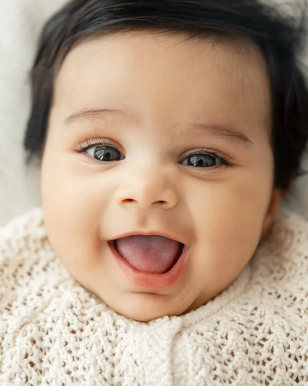 A perfect, joyful baby smile. This close-up shot is all about capturing that infectious happiness that can light up a whole room.