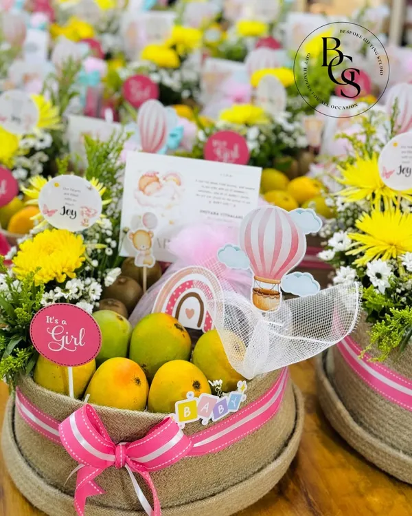 Announcing the arrival of a baby girl with these beautiful and healthy fruit hampers. Each jute basket is filled with fresh fruits and flowers, decorated with pink ribbons and "It's a Girl" tags.