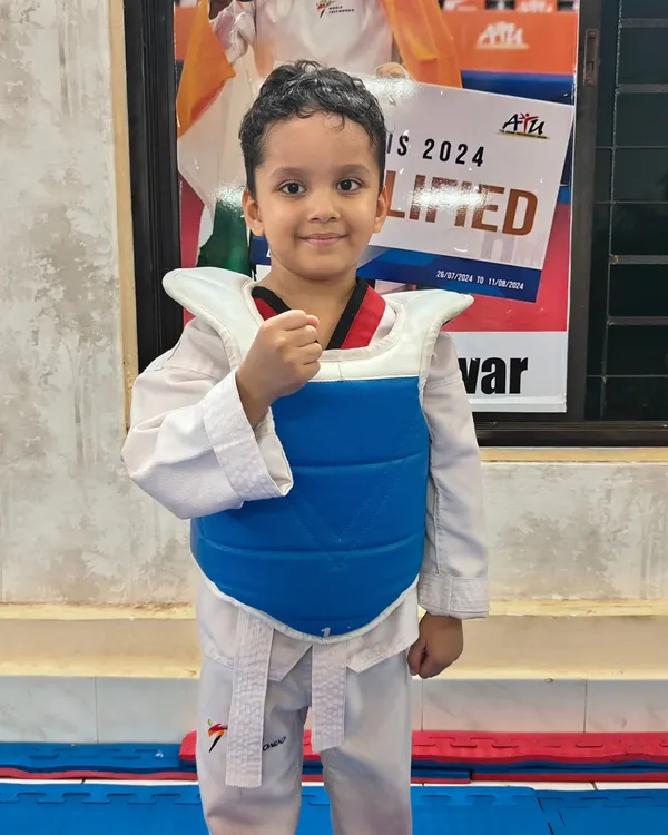 A proud young student in his protective gear. We make sure even our smallest warriors feel confident and safe as they learn.