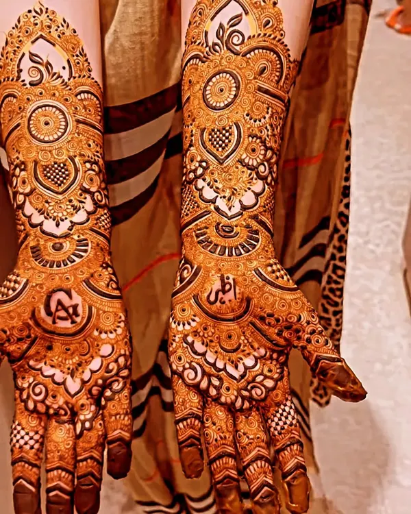 A beautiful example of non-bridal mehendi with full coverage, featuring personalized initials hidden within the intricate patterns.