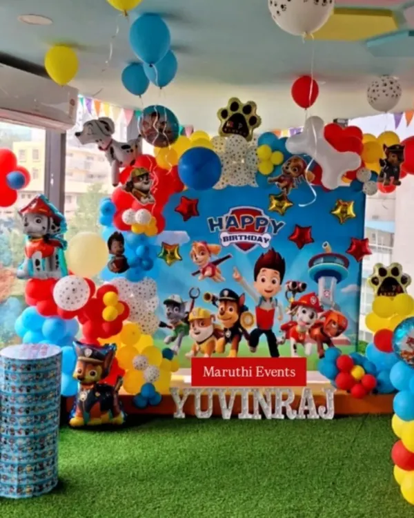 A complete Paw Patrol birthday setup for Yuvinraj. This decoration features a large character backdrop, balloon arrangements in the show's signature colors, and themed pedestals.