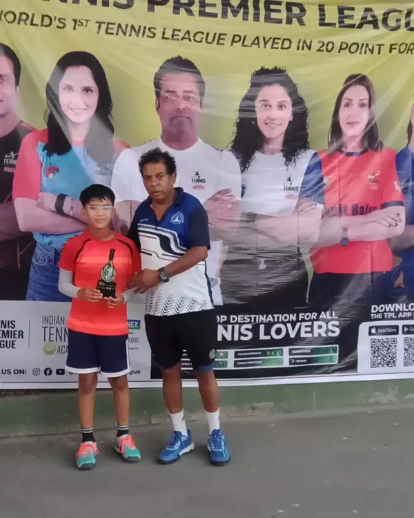 One of our junior champions receiving his winner's trophy from our coach at the TPL-ITA Tennis Tournament. Celebrating success is a big part of our academy's culture.