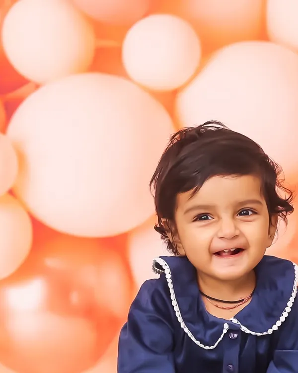 A beautiful, happy smile from a baby girl during her studio session. The soft, bubbly background adds a touch of fun to this classic sitter portrait.