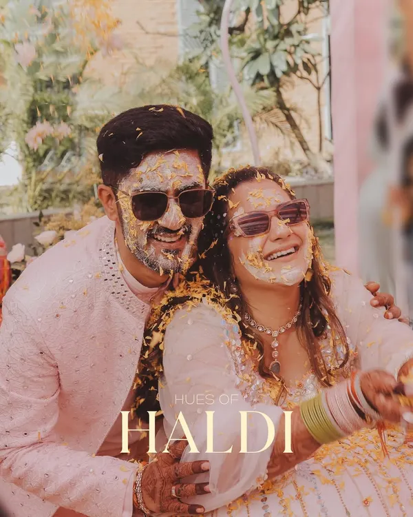 The calm before the beautiful storm of flowers and turmeric. This shot captures the couple's happy smiles and cool shades, ready for the Haldi fun to begin.