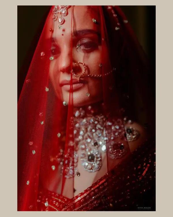 A moment of stillness behind the veil. I use light and shadow to create moody, artistic bridal portraits that are full of emotion and mystique. This shot focuses on the bride's eyes and the delicate details of her Falguni Shane Peacock ensemble.