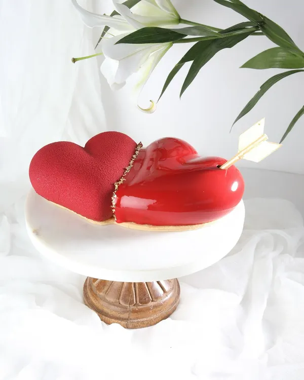 Cupid's masterpiece. This stunning heart-shaped entremet cake, with its glossy red glaze and velvet texture, is designed to make Valentine's Day unforgettable.