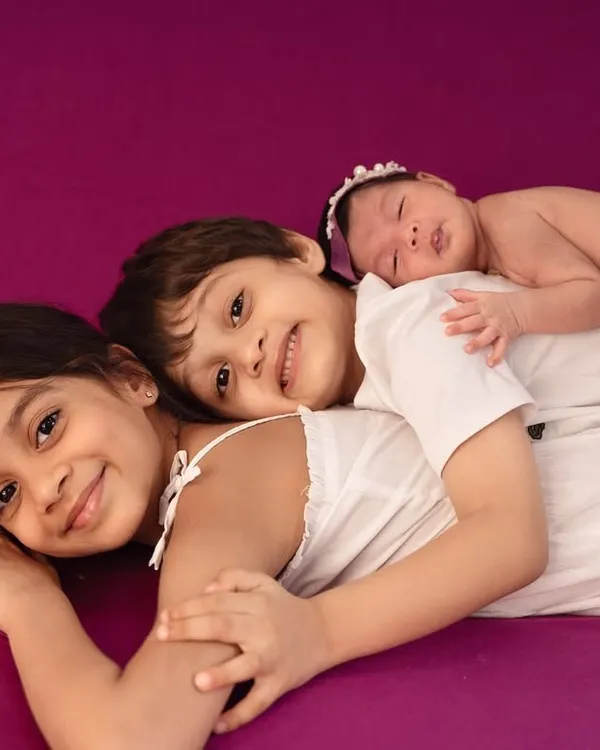 A pile of love. I gently guide siblings into comfortable, sweet poses that show their excitement and affection for the newest family member.