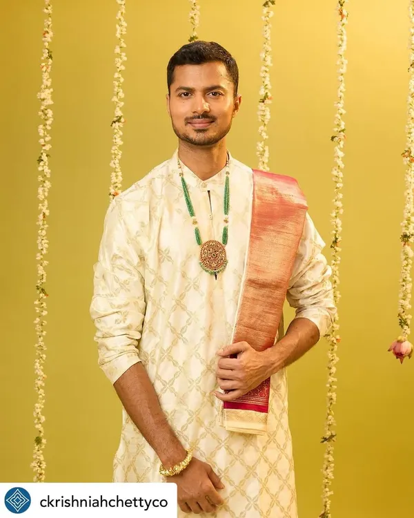 A solo shot from the C. Krishniah Chetty campaign, modeling a classic cream kurta with an emerald green necklace. The look is simple, elegant, and timeless.